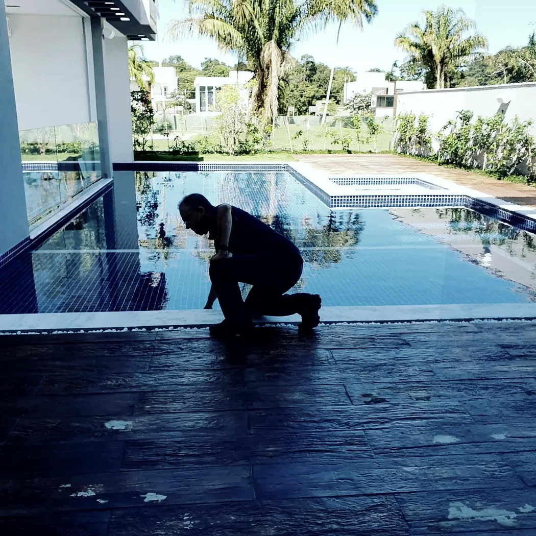 Profissional trabalhando na borda de uma piscina em obra de aquecimento