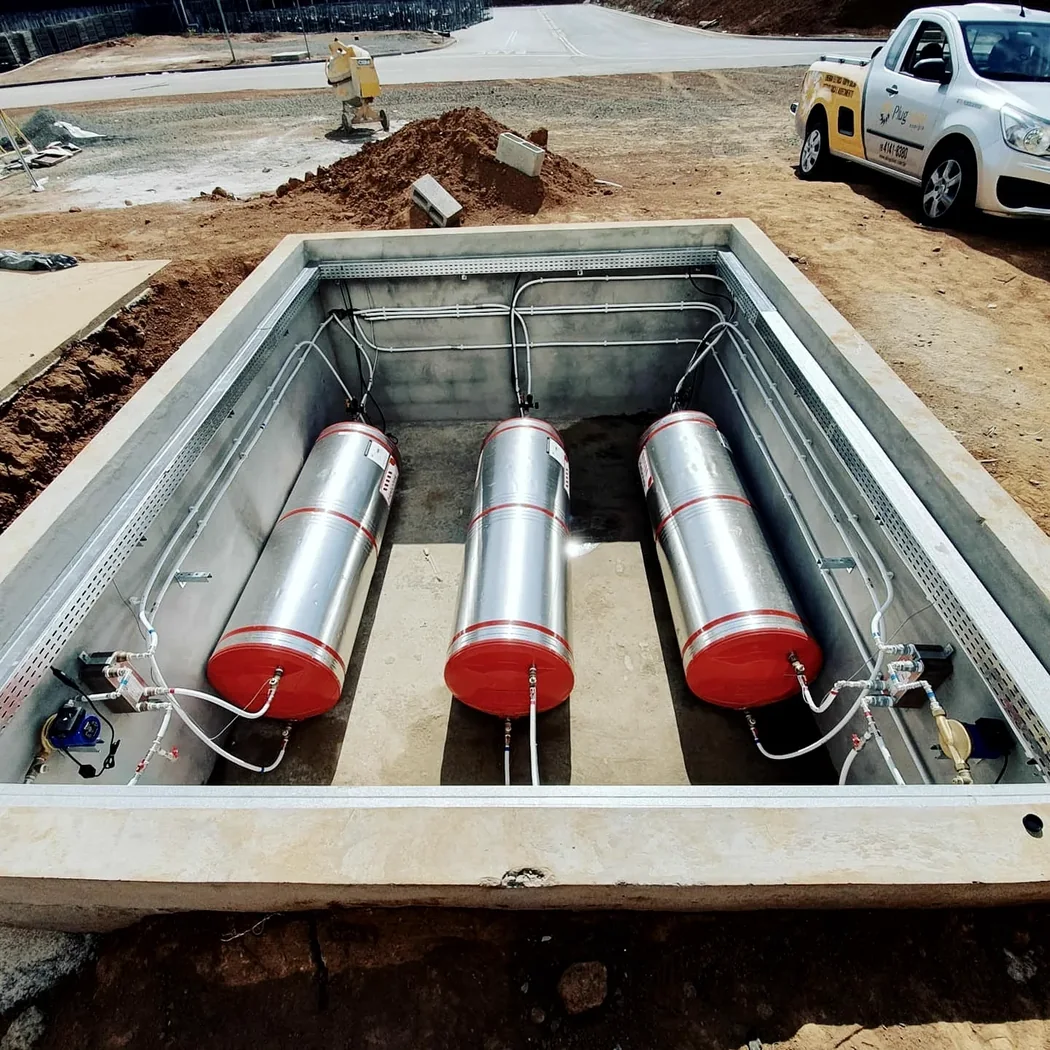 Três reservatórios térmicos instalados em base de alvenaria durante a obra