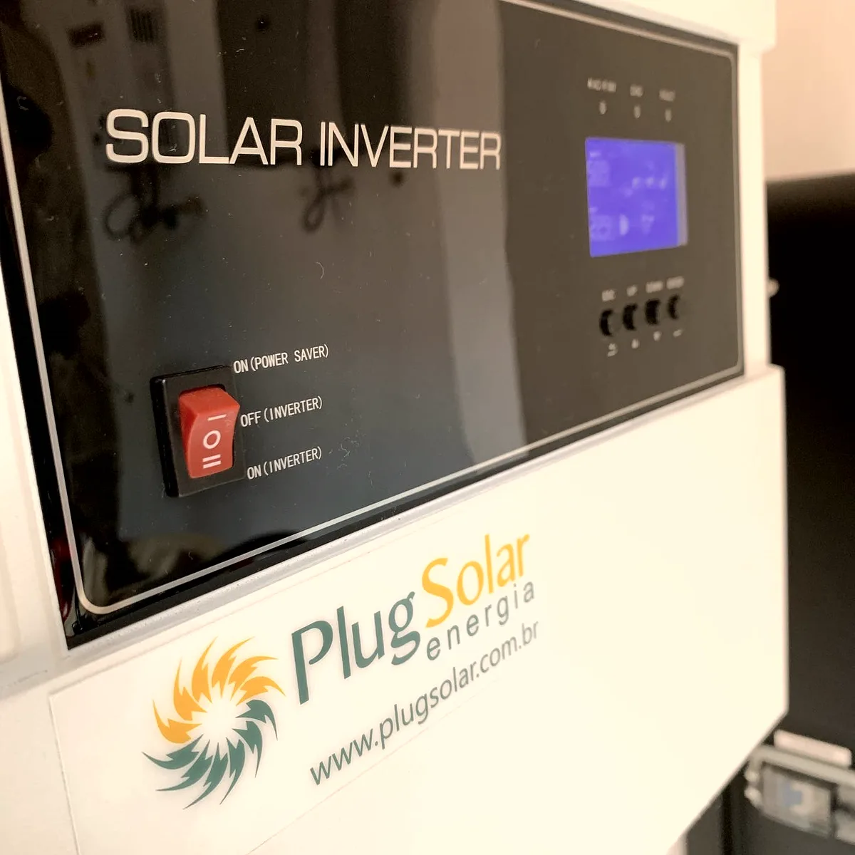 Inversor solar instalado, com a marca Plug Solar Energia impressa no painel frontal do equipamento