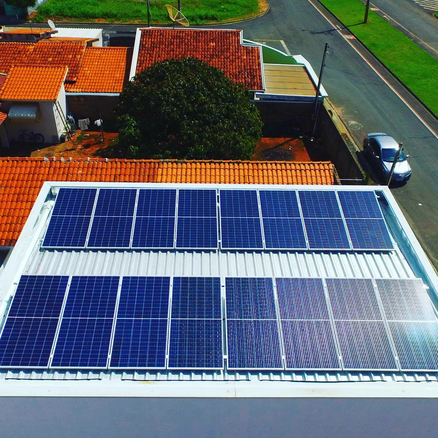 Vista aérea de telhado colonial com um conjunto de módulos fotovoltaicos instalados em fileiras diagonais