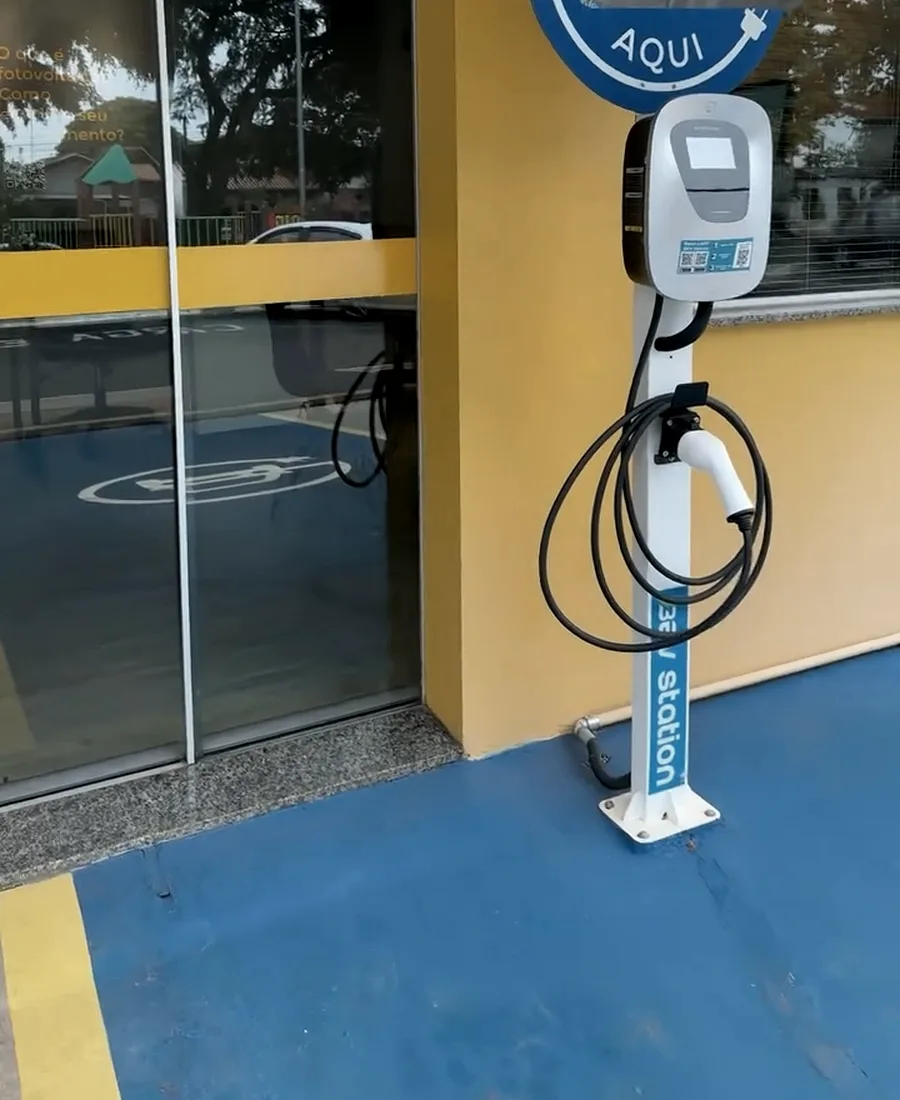 Estação de recarga instalada em vaga demarcada na entrada de um estabelecimento comercial