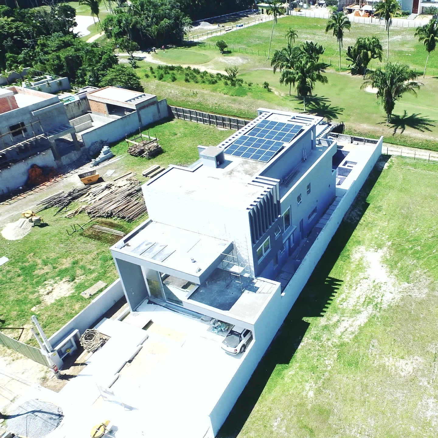 Vista aérea de conjunto de edifícios em obra, com módulos fotovoltaicos instalados na cobertura