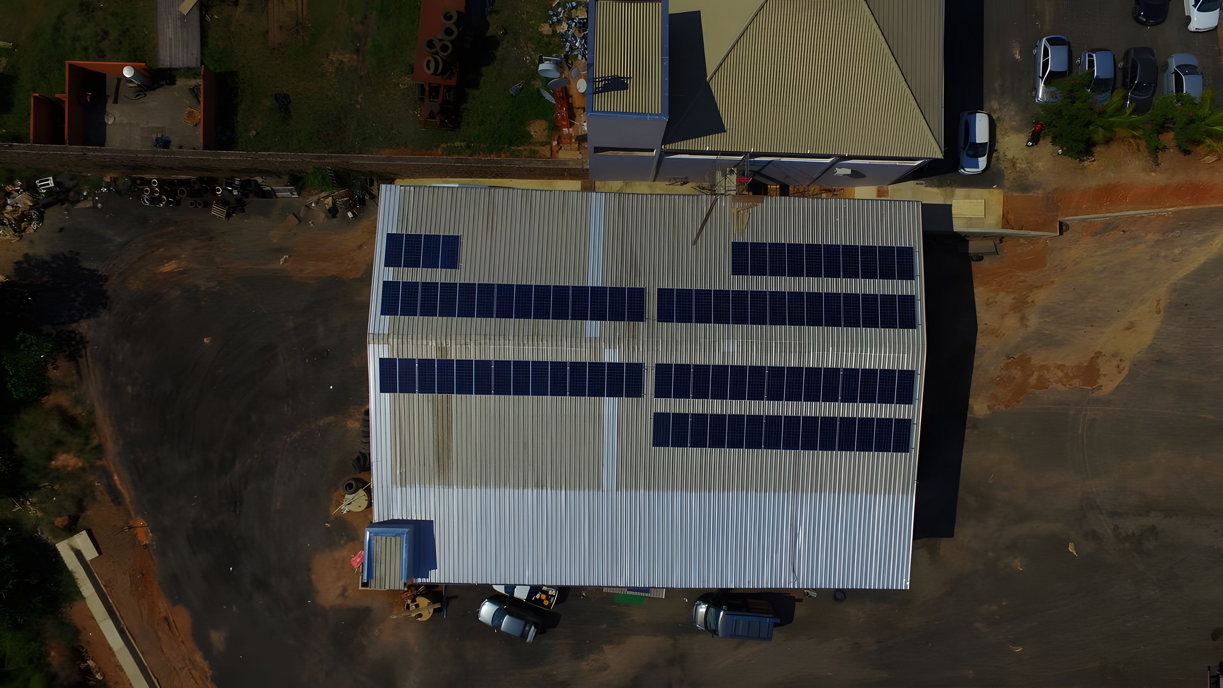Galpão comercial visto do alto, com módulos fotovoltaicos cobrindo a área útil do telhado