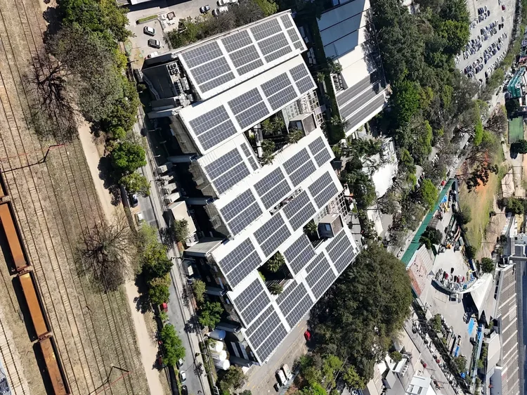 Cobertura de prédio comercial fotografada a prumo, com o arranjo de módulos fotovoltaicos ocupando toda a laje