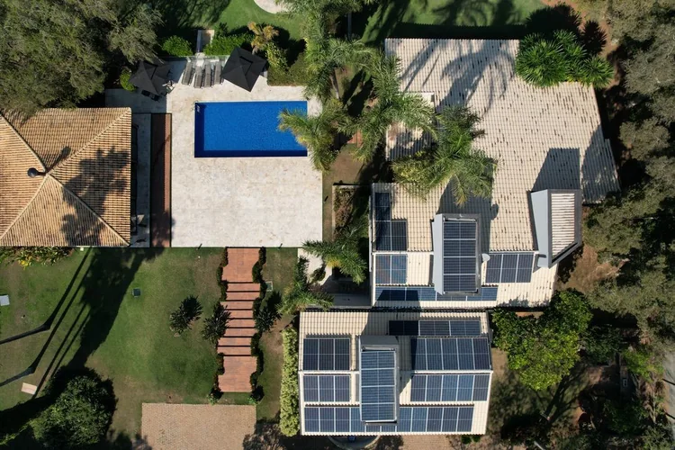 Residência com piscina e módulos fotovoltaicos instalados na cobertura principal
