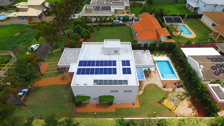Sobrado residencial com módulos fotovoltaicos cobrindo a água do telhado voltada para o sol